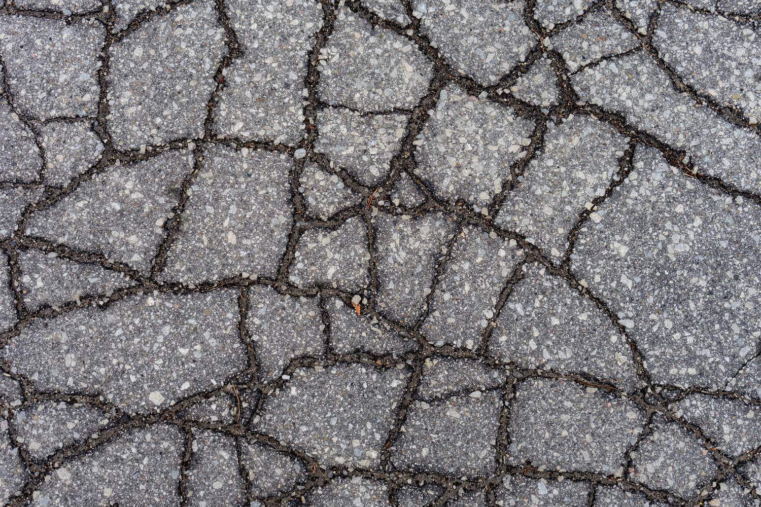 summer pavement damage in a school parking lot before fall repair