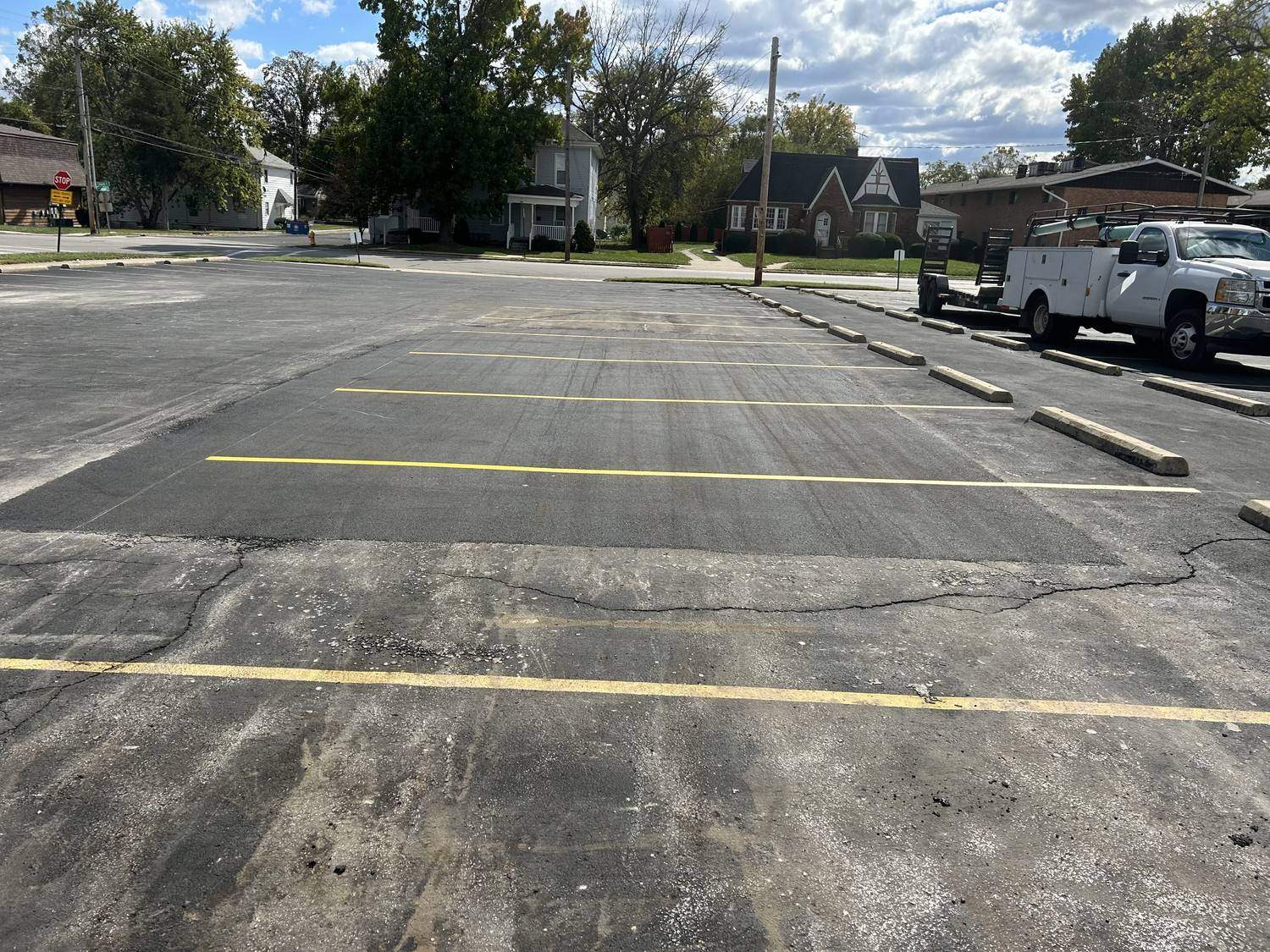 Newly repaved section of a commercial parking lot with fresh yellow line striping.