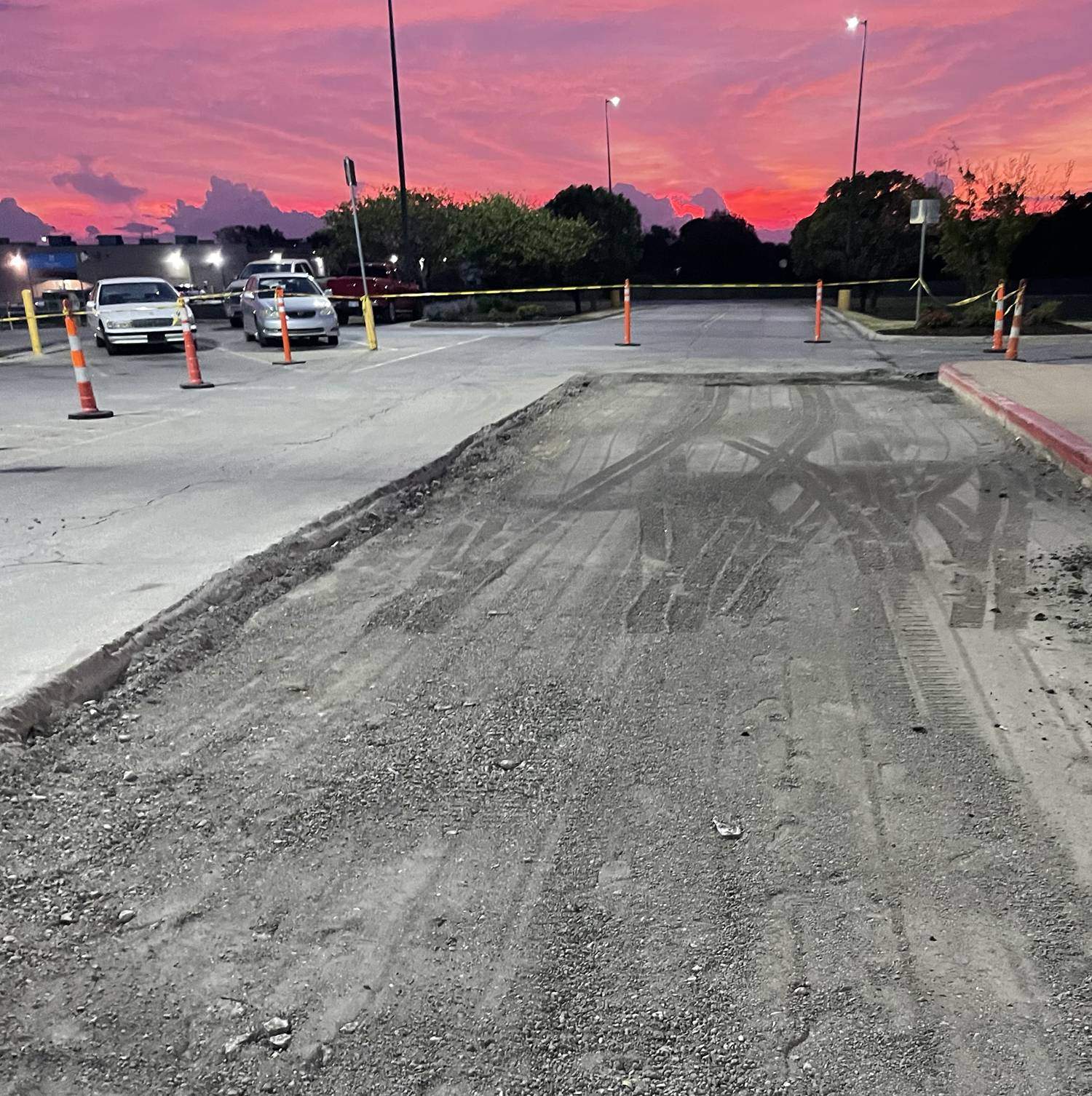 Commercial parking lot paving preparation and excavation by K&K Asphalt Services in Edwardsville, IL under a sunset sky.

